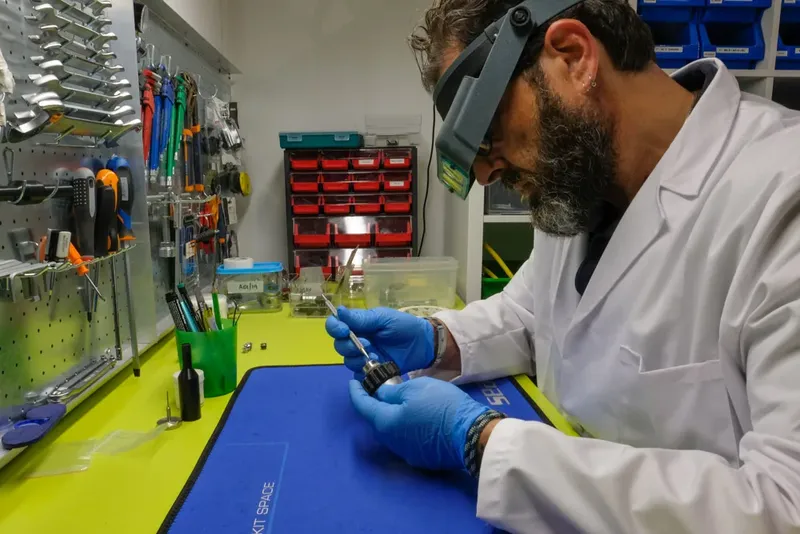 Un technicien répare un détendeur de plongée avec précision et concentration