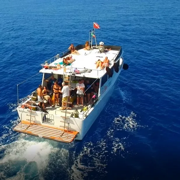 Bateau de plongée en mer avec des plongeurs se préparant