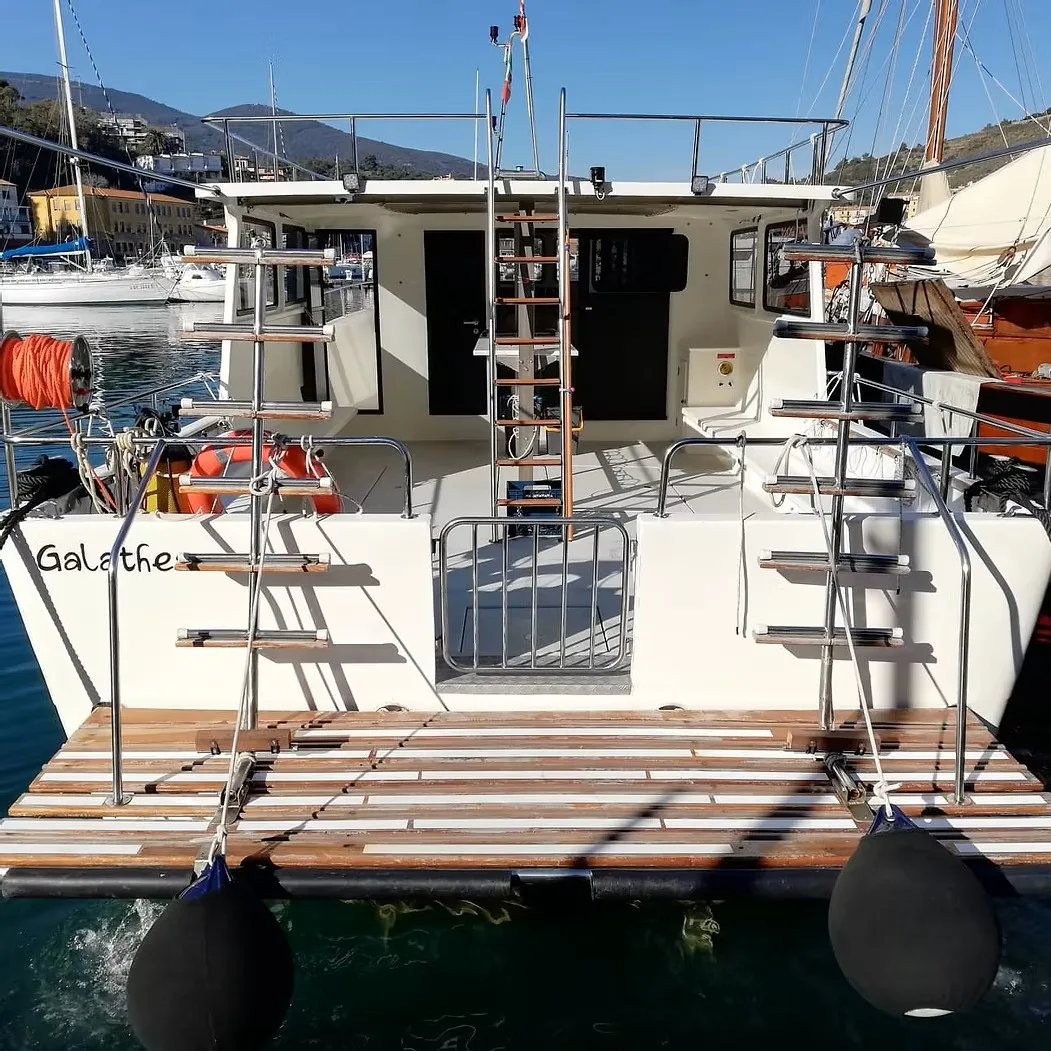 Vue arrière d'un bateau de plongée amarré dans un port ensoleillé