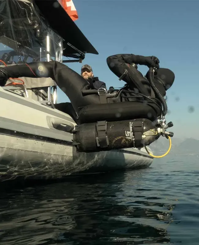 Plongeur s'apprête à entrer dans l'eau depuis un bateau pneumatique