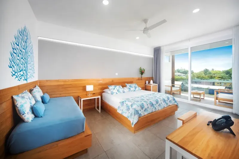 Chambre d'hôtel moderne avec lits, canapé et vue sur l'extérieur