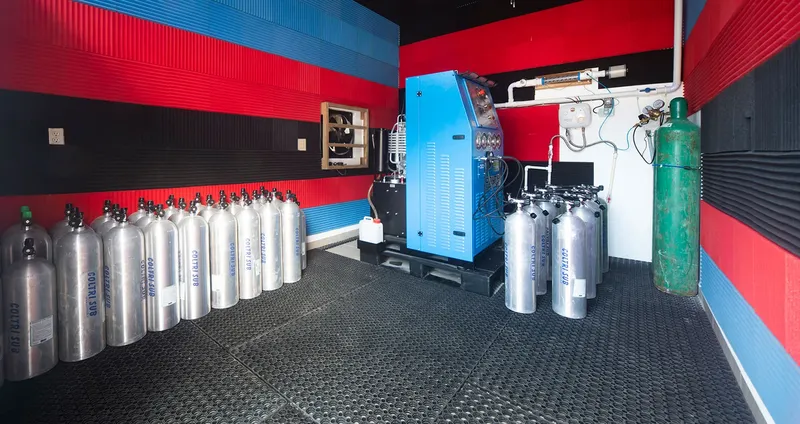 Salle de compression avec rangées de bouteilles et compresseur bleu
