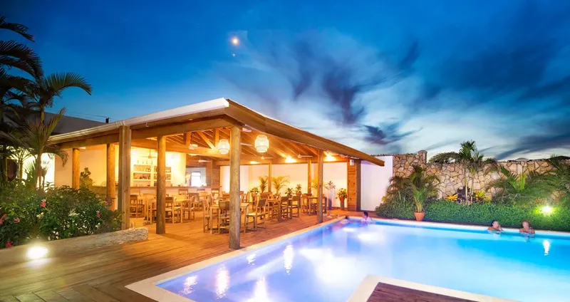 Terrasse lumineuse avec piscine et quelques personnes se relaxant au bord