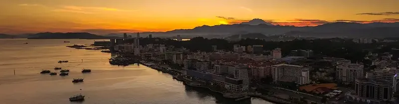 Vue panoramique d'une ville côtière au coucher du soleil avec bateaux