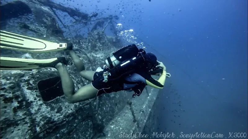 Plongeuse explorant une épave sous-marine avec son équipement complet