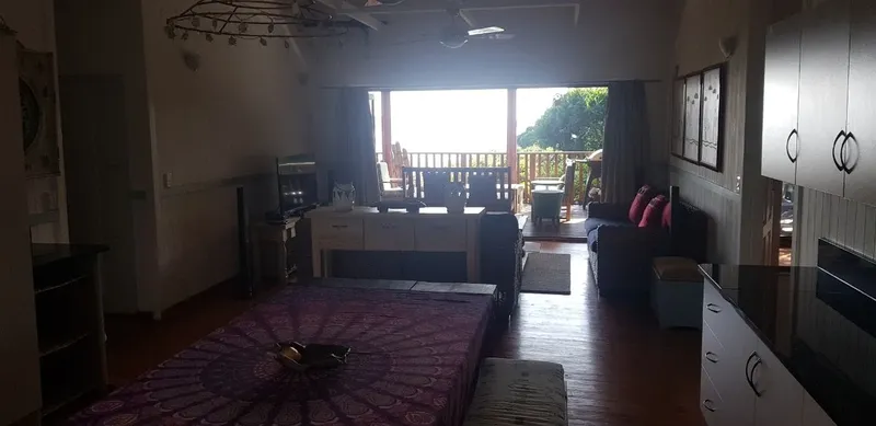 Interieur d'un logement avec cuisine, lit et vue sur terrasse