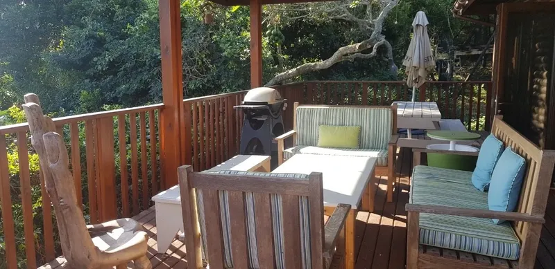 Terrasse en bois avec mobilier, équipement de plongée et végétation luxuriante