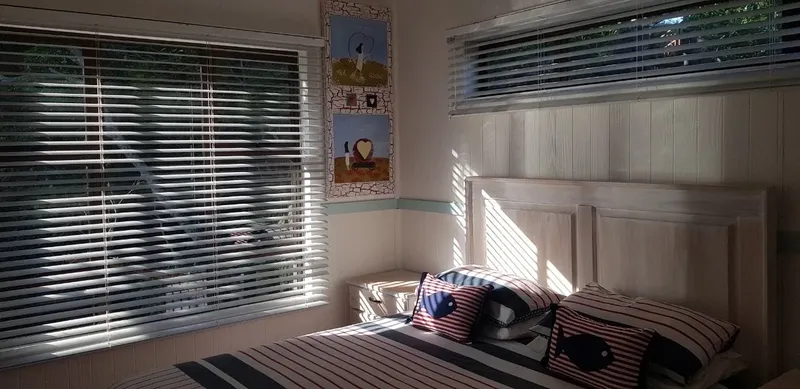 Chambre avec lit rayé, coussins bleus et décoration marine