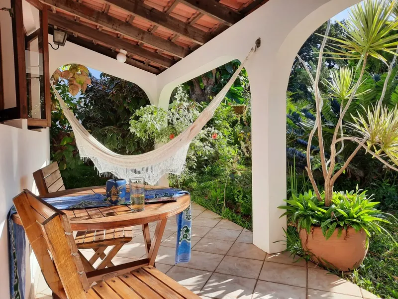 Terrasse ombragée avec hamac, table en bois et végétation luxuriante