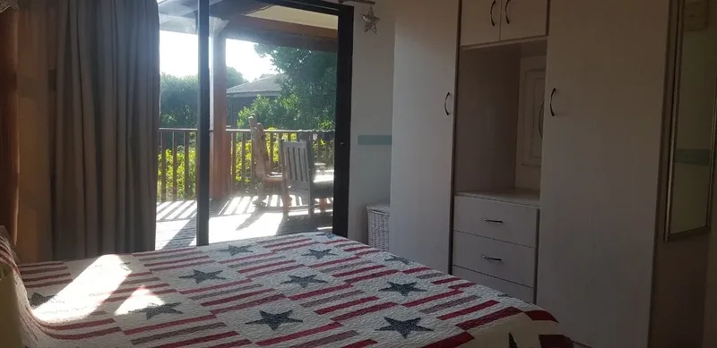 Chambre avec lit étoilé donnant sur une terrasse et végétation luxuriante