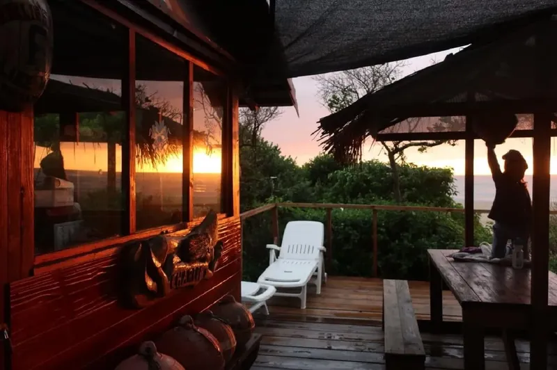 Terrasse en bois avec bouteilles, chaises longues et personne préparant matériel