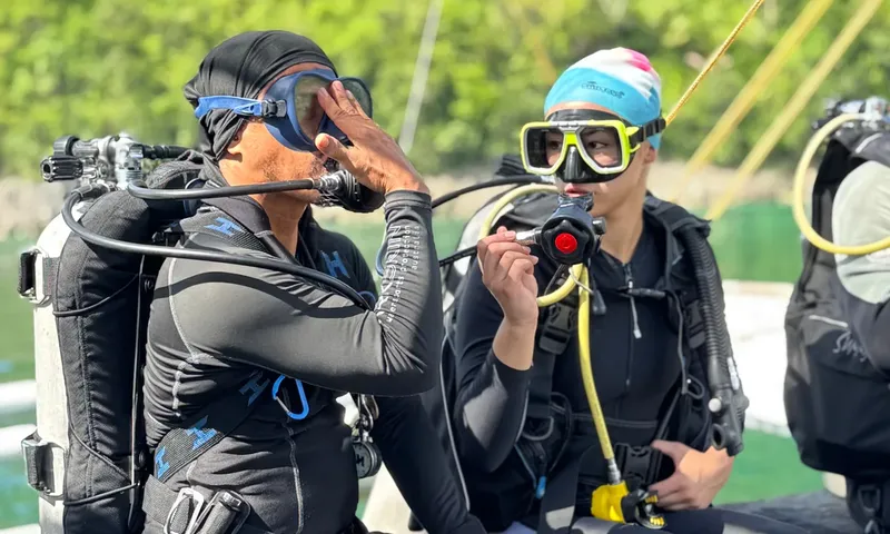 Deux plongeurs vérifient leur équipement avant une immersion en mer