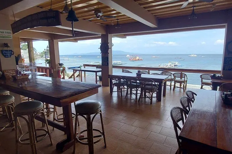 Terrasse d'un centre de plongée avec vue sur la mer et bateaux