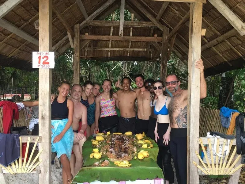 Groupe de personnes souriantes posant devant une table de fruits exotiques