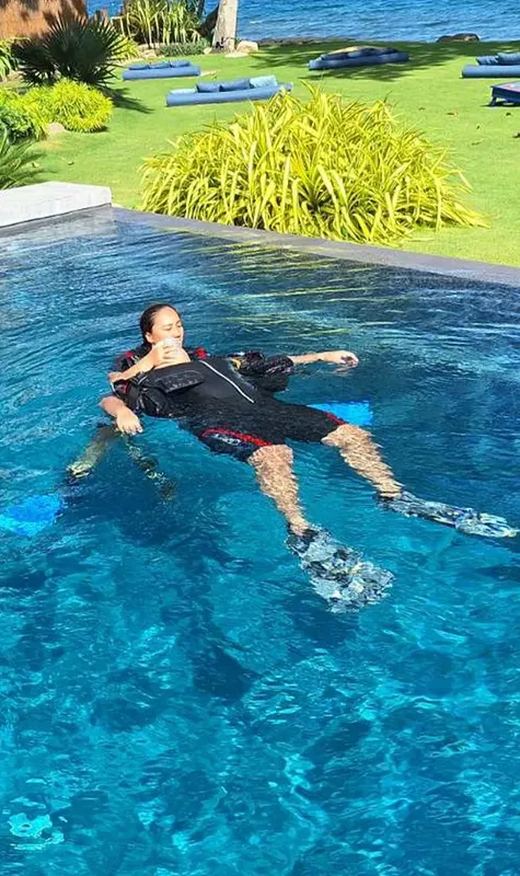 Plongeur en surface, équipé, flottant dans une piscine bleu clair