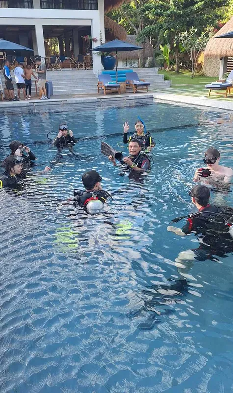 Groupe de personnes en combinaison de plongée dans une piscine
