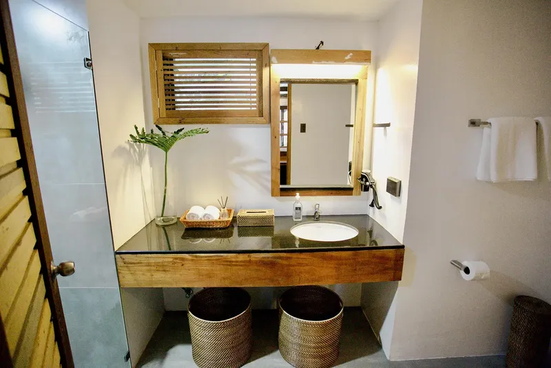 Salle de bain moderne avec vasque en bois et décoration tropicale