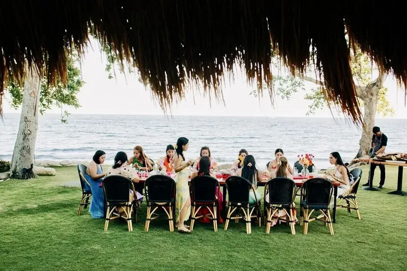 Groupe de personnes assises autour d'une longue table en extérieur