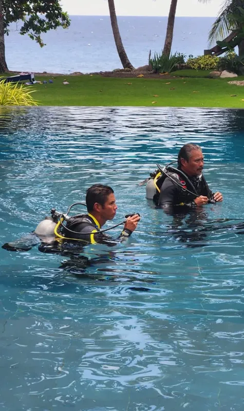 Deux plongeurs s'entraînent dans une piscine avec leur équipement complet
