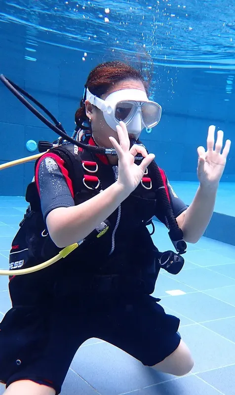 Plongeuse en piscine fait le signe OK avec ses mains