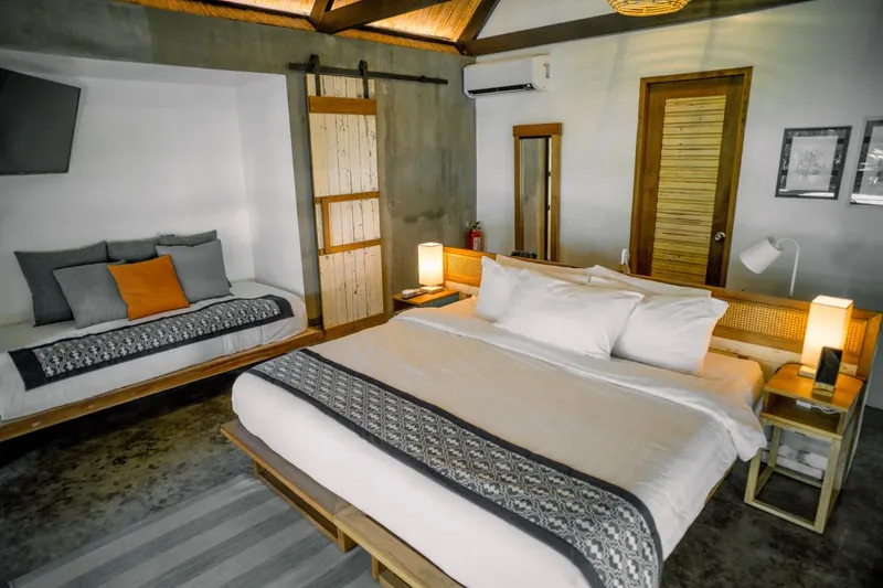 Chambre d'hôtel moderne avec lit et canapé, éclairage chaleureux
