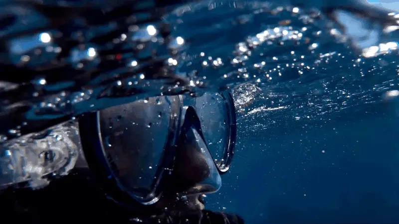Visage d'un plongeur avec masque et tuba sous la surface de l'eau