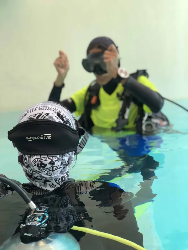 Deux plongeurs en formation, l'un signale avec ses mains