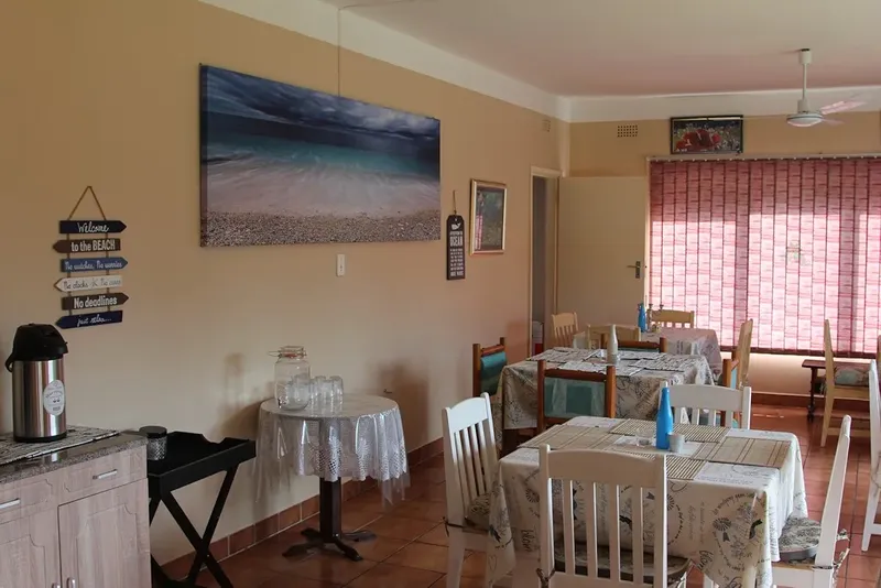 Salle de restaurant avec tables nappées et décoration marine lumineuse