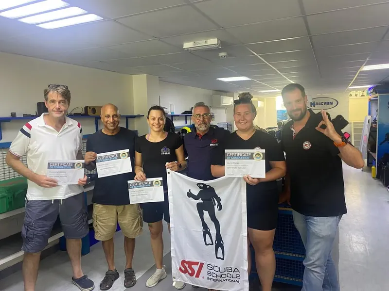 Groupe de plongeurs souriants tenant leurs certificats de formation