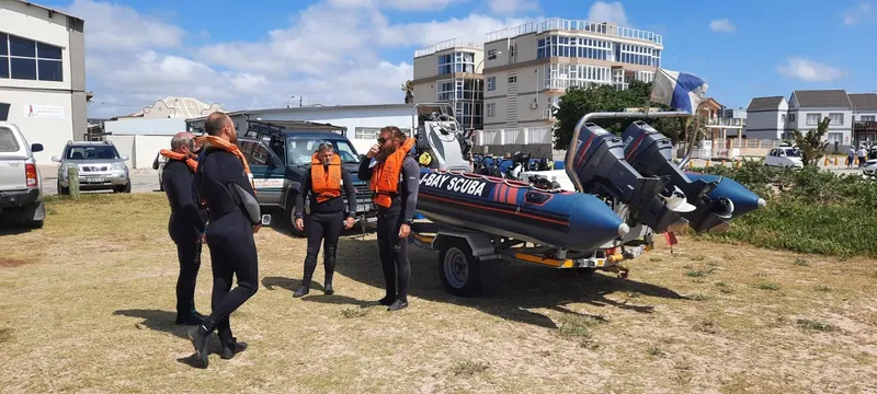 Groupe de plongeurs près d'un bateau semi-rigide sur remorque