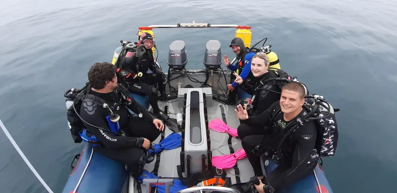 Plongeurs souriants à bord d'un bateau semi-rigide en mer