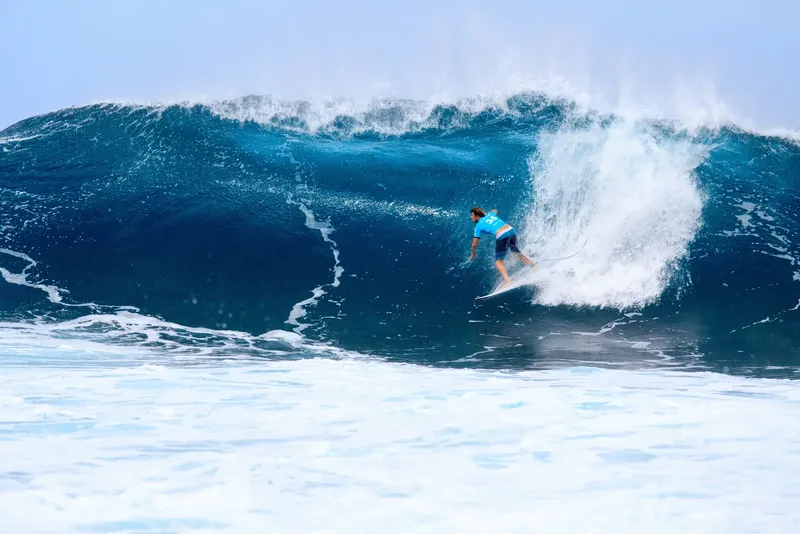 Surfeur glissant sur une vague puissante et creuse en pleine mer