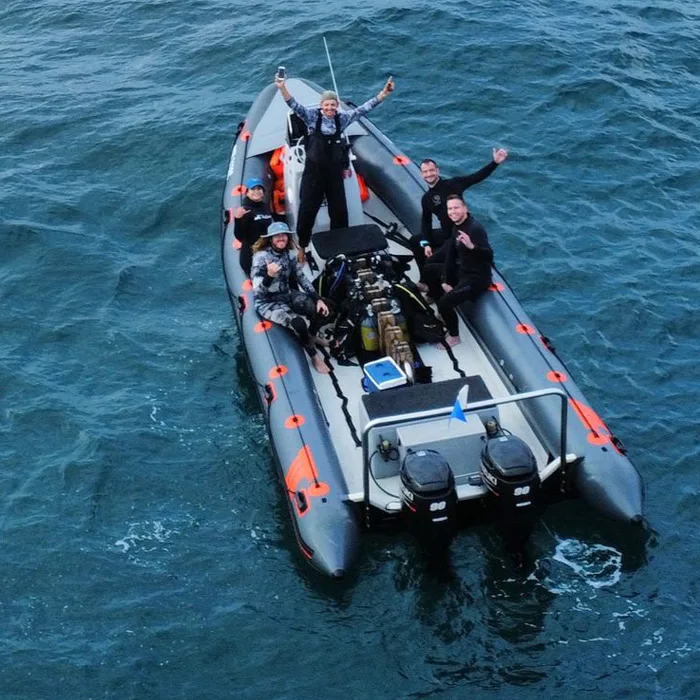 Quatre personnes souriantes sur un bateau semi-rigide en mer