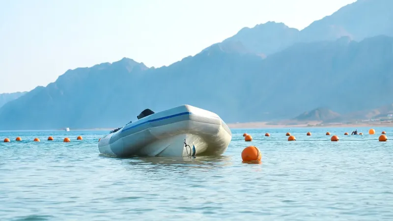 Bateau de plongée amarré sur une mer calme avec montagnes en arrière-plan