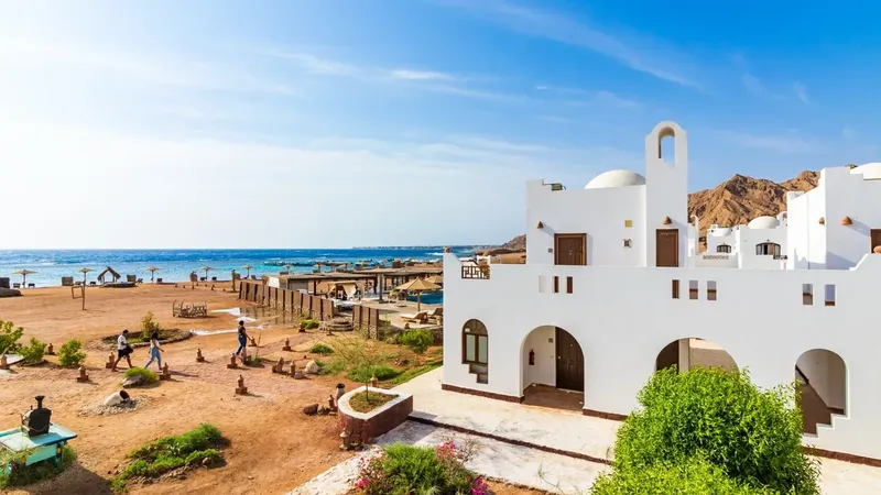 Bâtiment blanc et personnes se promenant près de la mer et des bateaux