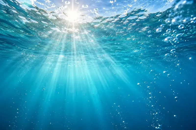 Rayons de soleil perçant la surface de l'eau bleue claire