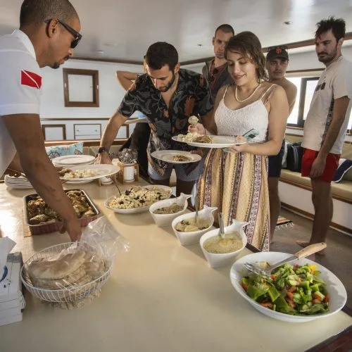 Buffet à bord d'un bateau avec des personnes se servant de la nourriture