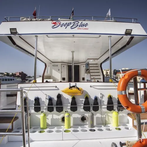 Bateau de plongée blanc avec équipement et logo du centre