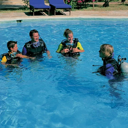 Cours de plongée en piscine avec instructeur et participants équipés