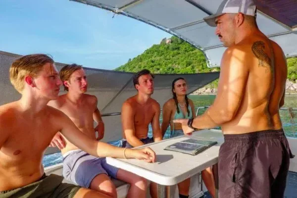 Groupe de personnes sur un bateau, un homme explique quelque chose