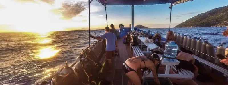 Bateau de plongée avec équipement et passagers au coucher du soleil