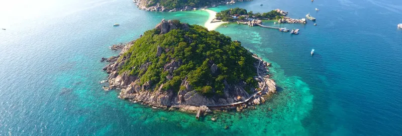 Vue aérienne d'une île tropicale avec des bateaux et une plage