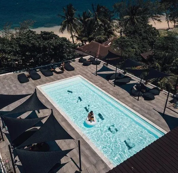 Vue aérienne d'une piscine avec des personnes se relaxant au soleil