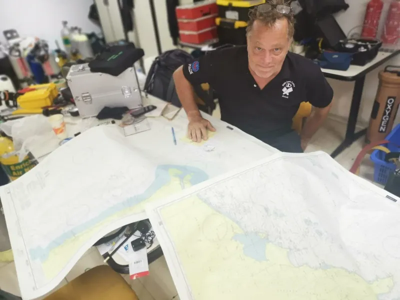 Un instructeur de plongée examine une carte marine dans un local