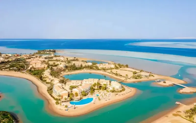 Vue aérienne d'un complexe hôtelier avec piscine et accès à la mer