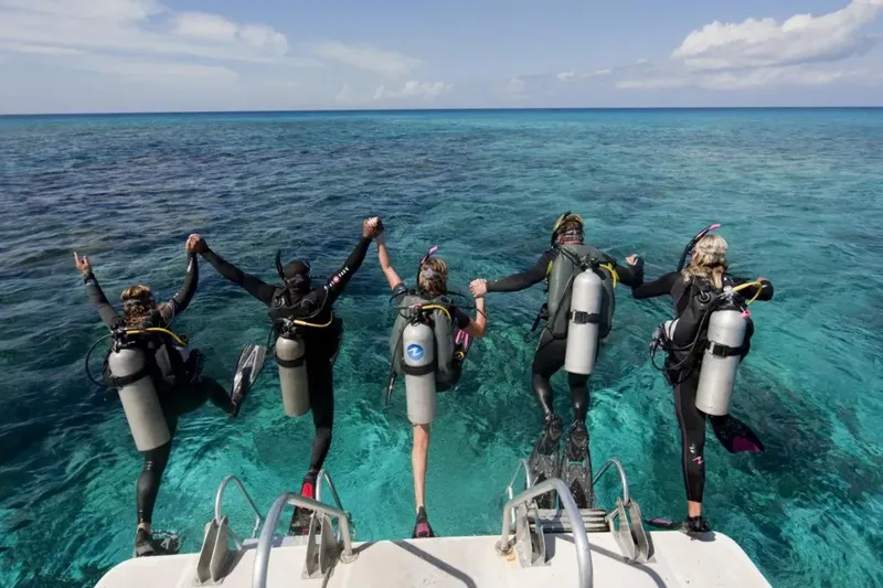 Groupe de plongeurs sur le point de sauter d'un bateau en mer