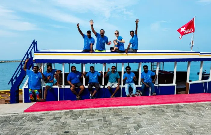Equipe souriante sur un bateau de plongée au bord de l'eau