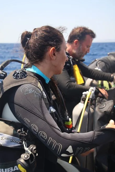 Deux plongeurs équipés sur un bateau, regardant vers l'horizon