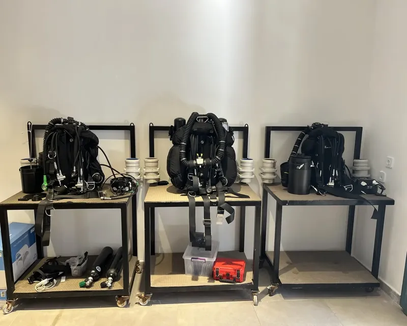 Equipements de plongée complets rangés sur des étagères métalliques noires