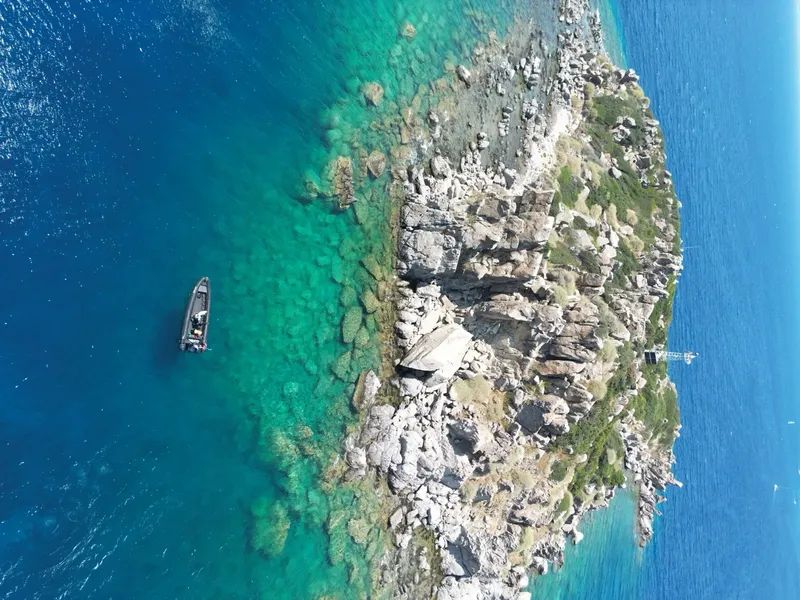 Vue aérienne d'un bateau de plongée près d'une côte rocheuse turquoise